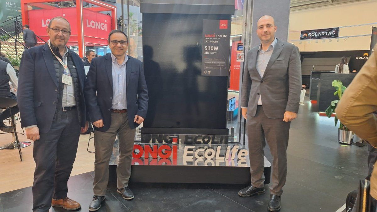 Tres profesionales posan junto a un panel solar LONGi EcoLife de 510W en un evento o feria del sector energético