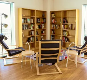A room with armchairs and bookshelves