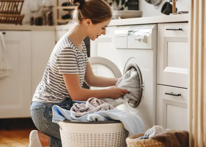Persona lavando ropa en una lavadora