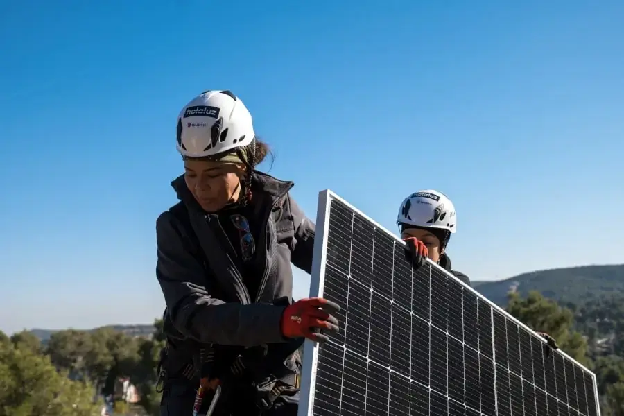 Two persons working together to install solar panels.